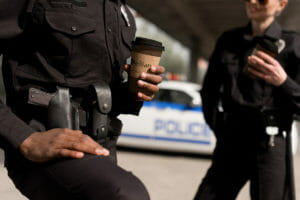Police holding a cup of Ellianos Coffee - National Coffee with a Cop Day