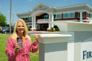 Gigi Register, First Federal Bank's Senior VP, pictured with Ellianos Coffee cup outside of First Federal's John S. Flood Financial Center in Lake City, FL.