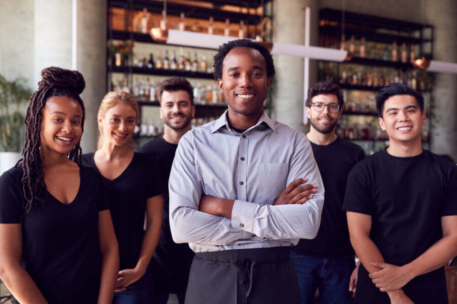 Franchise owner stands with team of staff