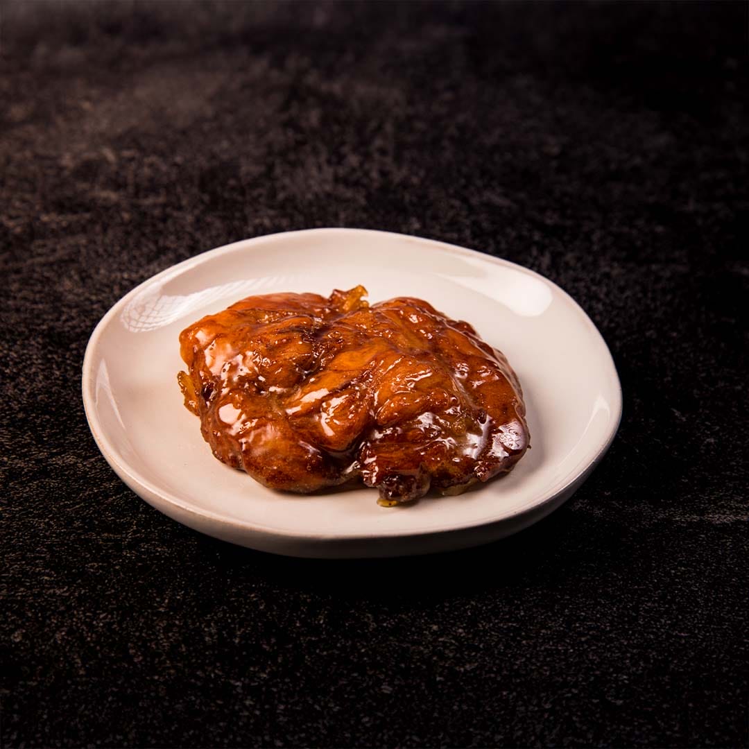 warm apple fritter on white plate
