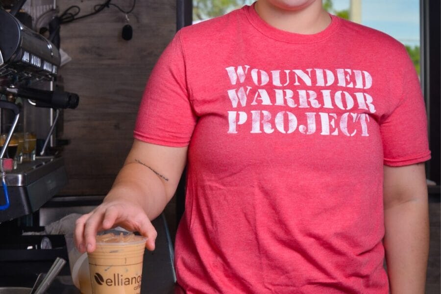 Girl in pink wounded warrior project shirt with ellianos coffee